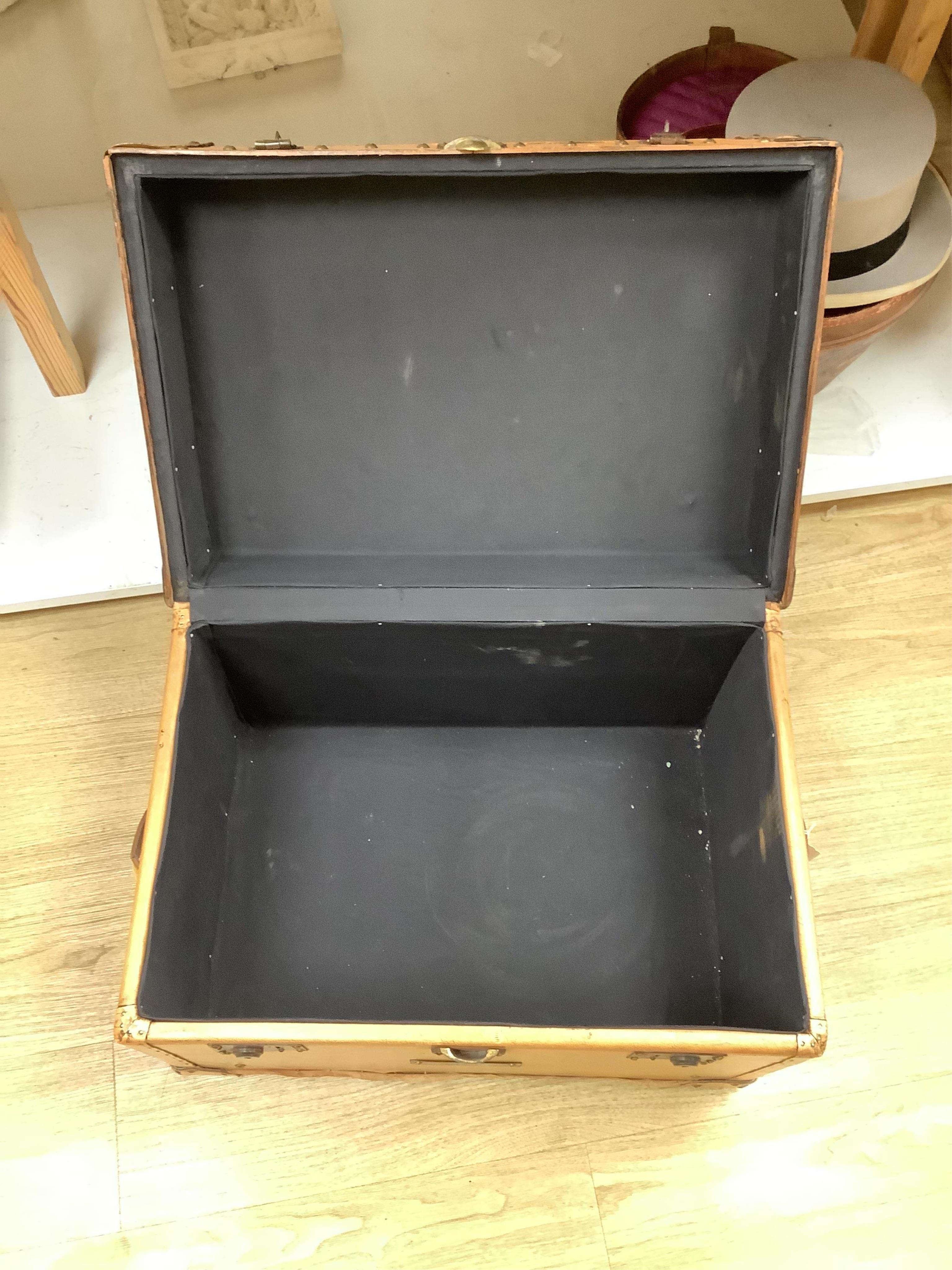 A leather trunk and top hat in box